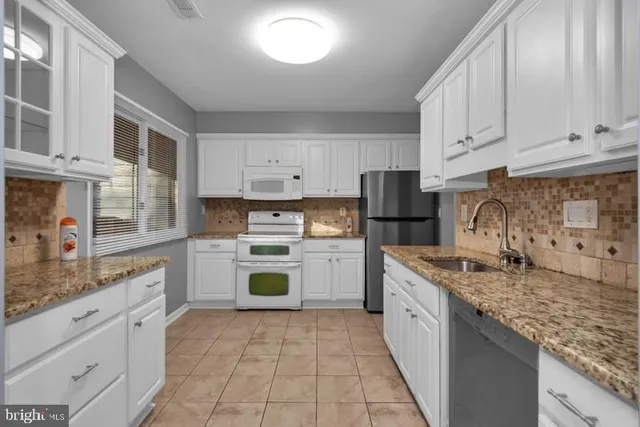 a kitchen with a stove top oven sink and cabinets