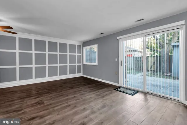 a view of empty room with wooden floor and floor to ceiling window