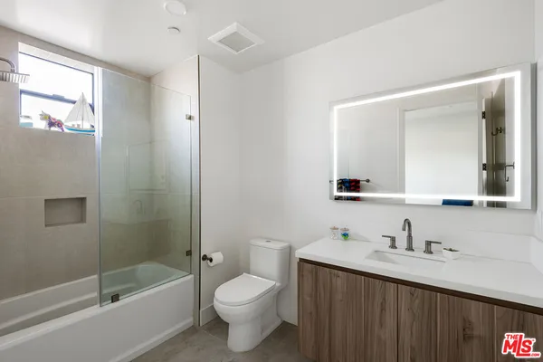a bathroom with a double vanity sink toilet and shower
