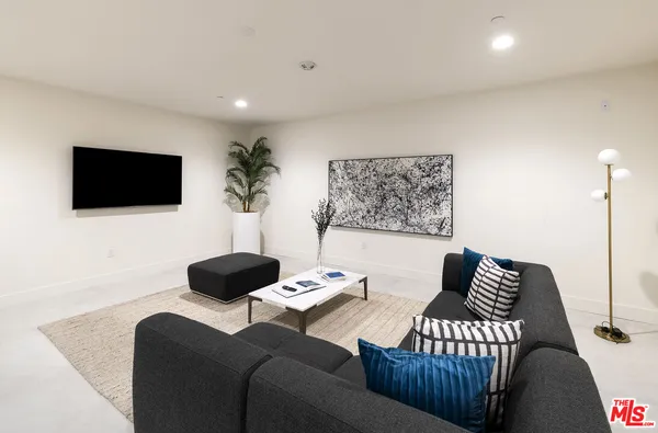 a living room with furniture a flat screen tv and a table