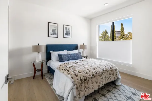 a bedroom with a bed and painting on the wall
