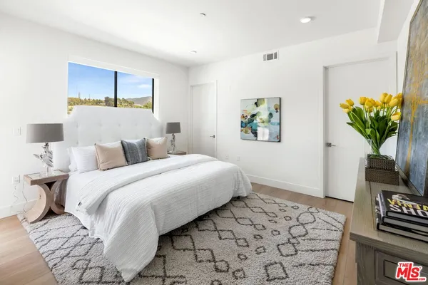 a bedroom with a bed and a painting on the wall
