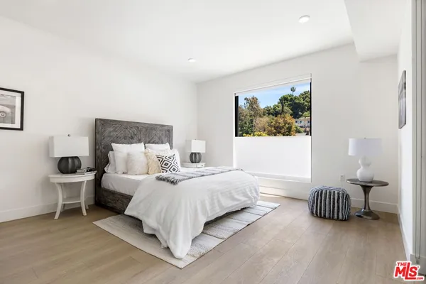 a spacious bedroom with a bed and a chair