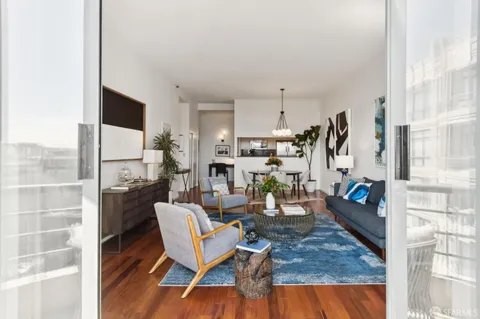 a view of a dining room with furniture a rug and wooden floor
