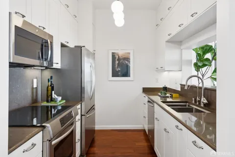 a kitchen with stainless steel appliances a sink a stove and a refrigerator