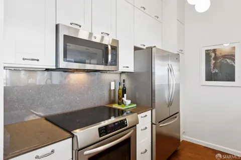 a kitchen with stainless steel appliances granite countertop a refrigerator and a stove top oven