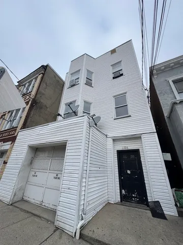 a view of a white house with a door and a large window