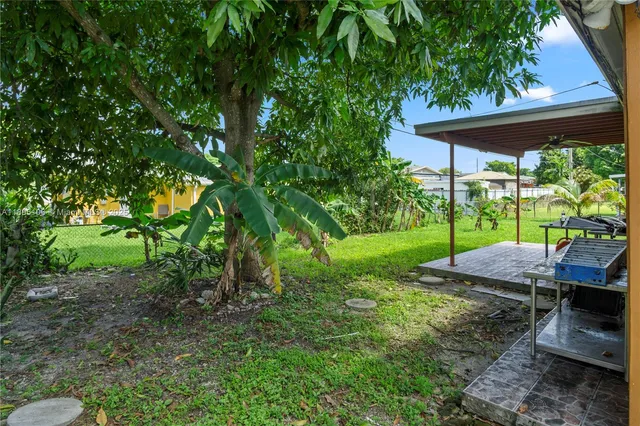 a view of a backyard with table and chairs under an umbrella