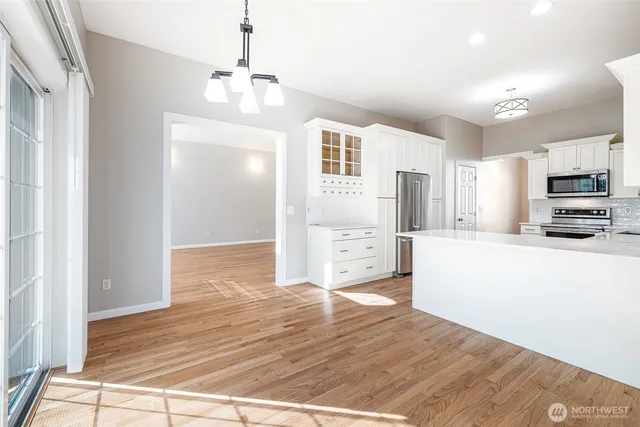 a view of a kitchen with wooden floor and a ceiling fan