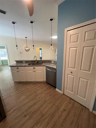 a kitchen with granite countertop a refrigerator and a sink