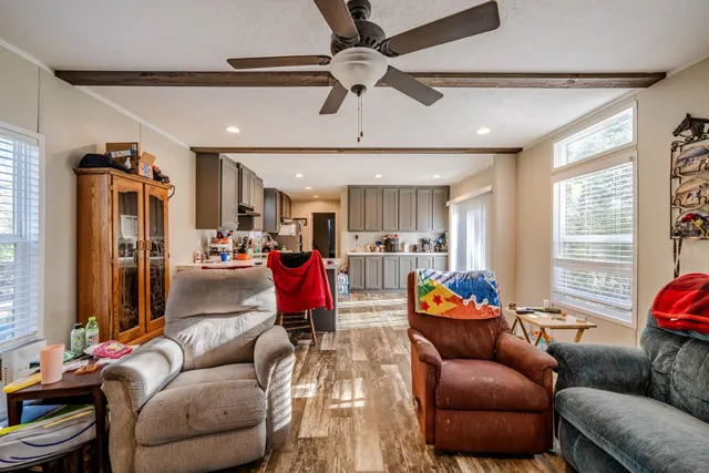 a living room with furniture kitchen view and a window
