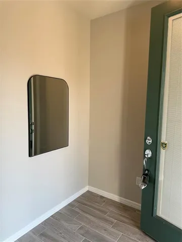 a view of a small space with wooden floor and a window