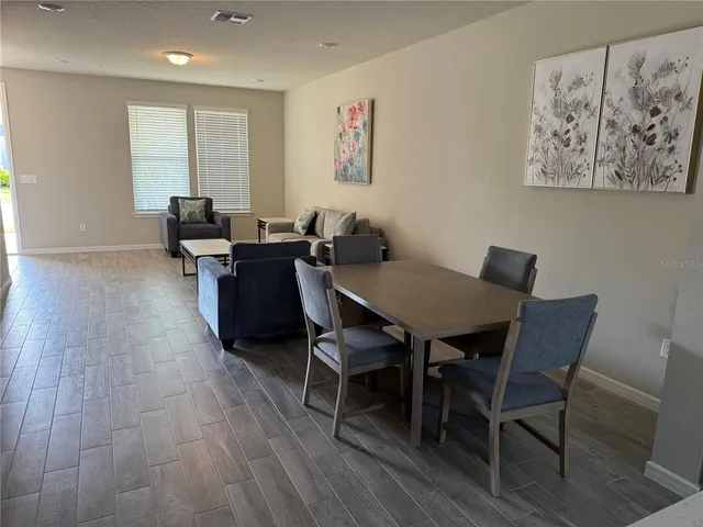 a view of a dining room with furniture window and wooden floor