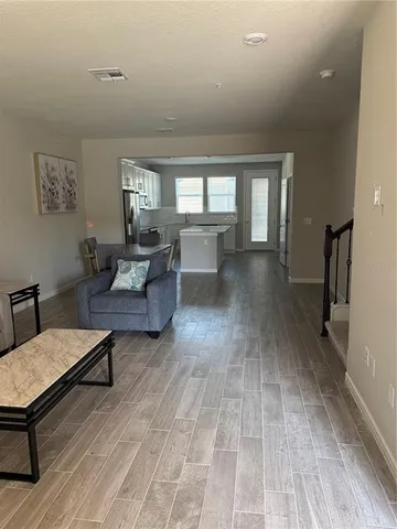 a living room with furniture and a wooden floor