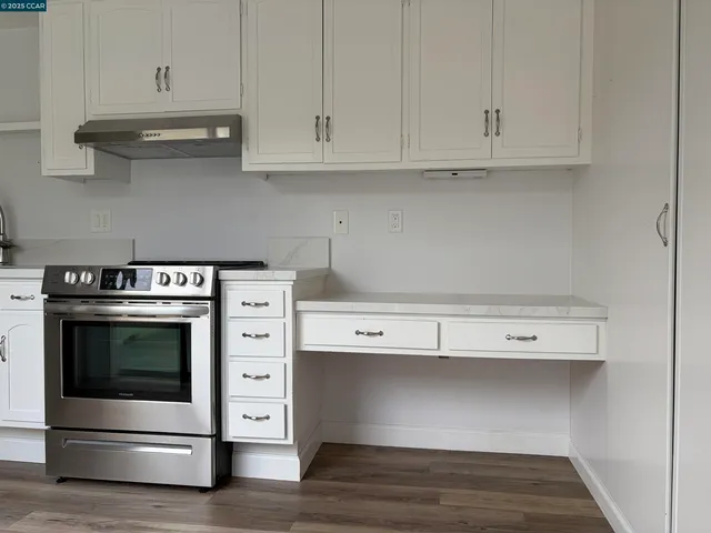 a kitchen with white cabinets and a stove