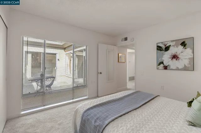 a bedroom with a bed and glass door