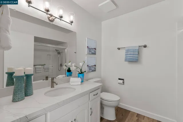 a bathroom with a granite countertop sink a toilet and mirror
