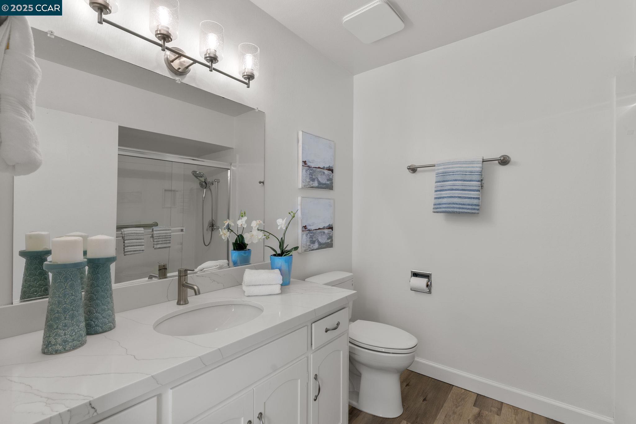 2017 Pine Knoll Drive, Unit 4 Walnut Creek, CA 94595 - Photo 14 of 21 a bathroom with a granite countertop sink a toilet and mirror