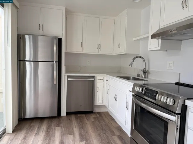 a kitchen with a stove refrigerator and sink