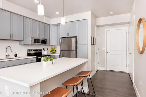 a kitchen with stainless steel appliances granite countertop a refrigerator sink and white cabinets