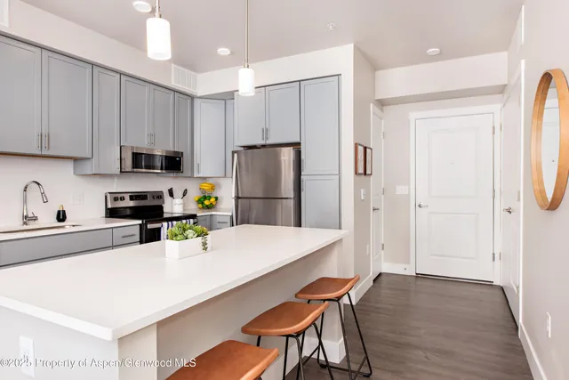 a kitchen with stainless steel appliances granite countertop a refrigerator sink and white cabinets