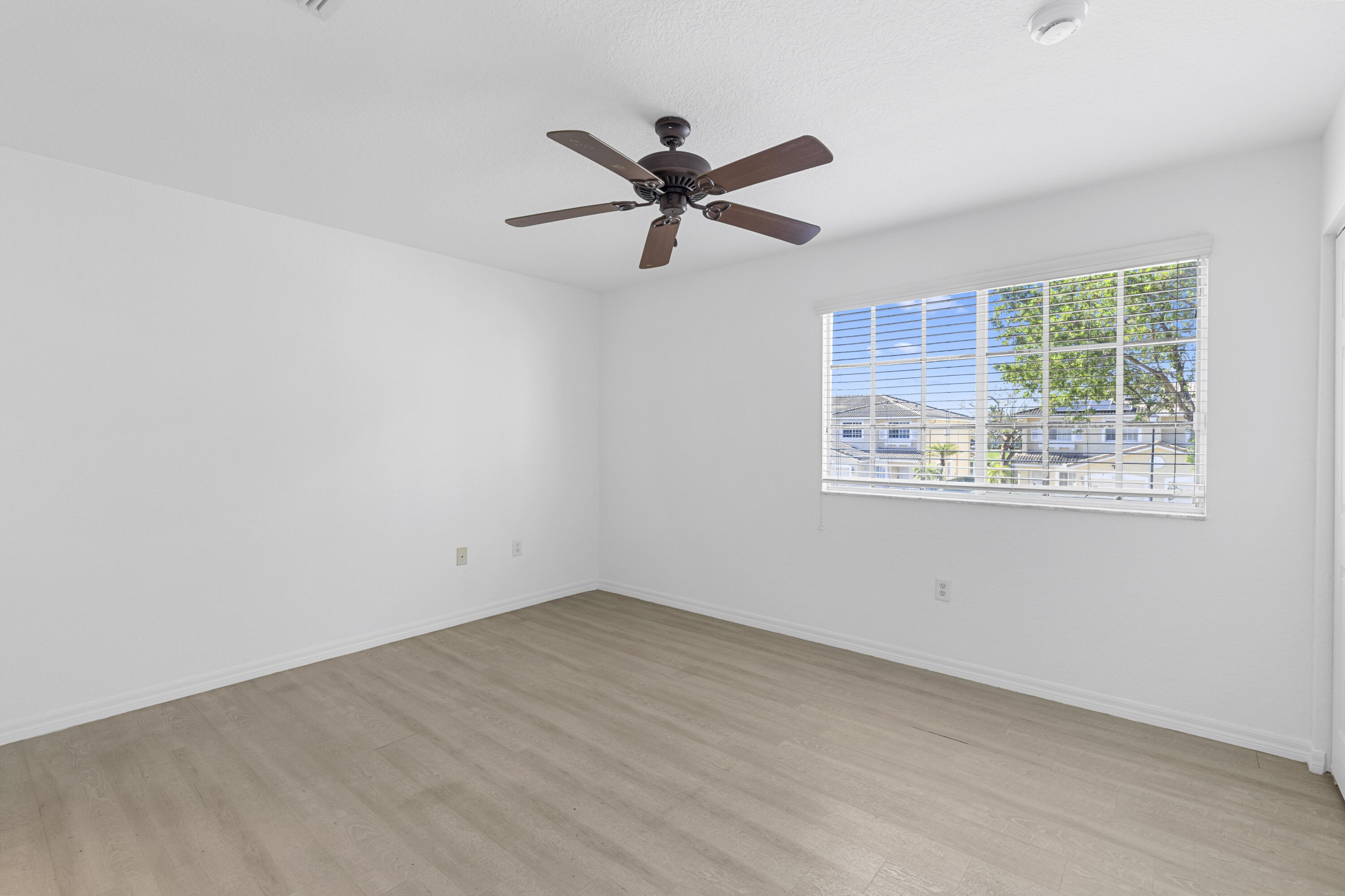 9107 Chambers Street, Unit 9107 Tamarac, FL 33321 - Photo 17 of 30 wooden floor in an empty room with a window