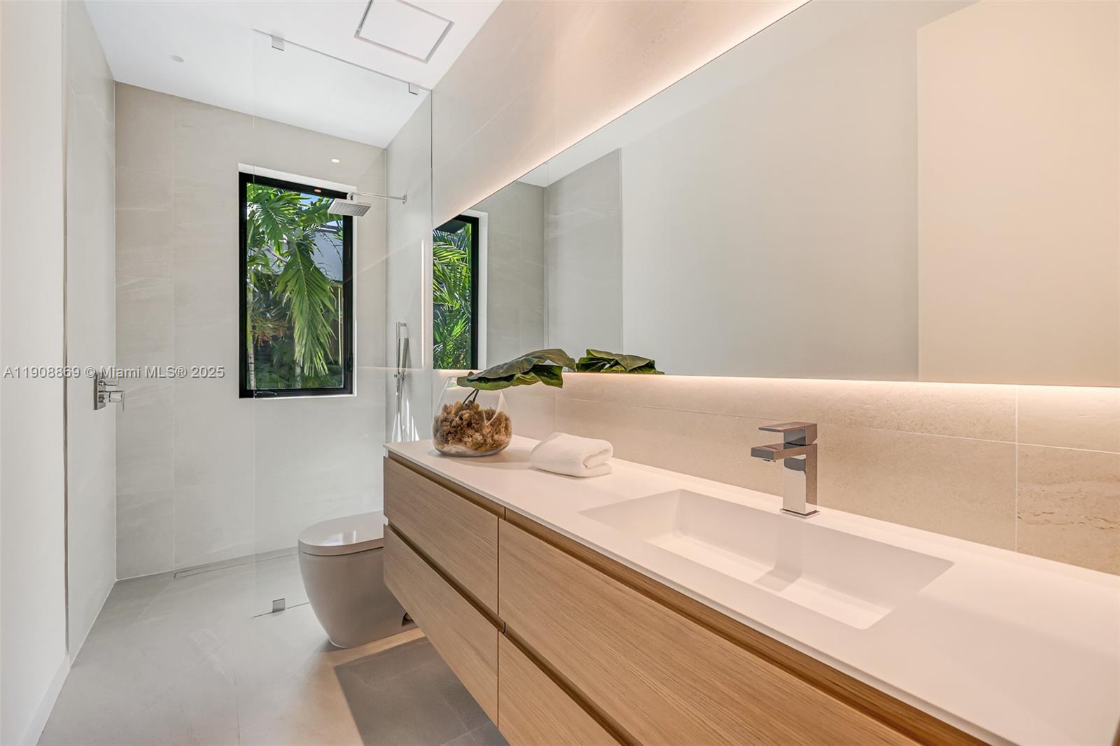 1661 Onaway Drive Miami, FL 33133 - Photo 21 of 26 a bathroom with a sink and a large mirror
