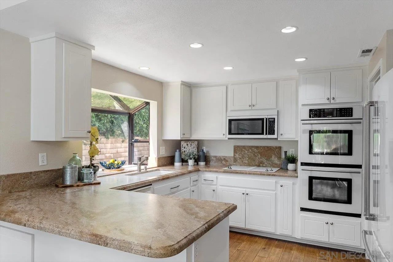 3355 Lower Ridge Road San Diego, CA 92130 - Photo 6 of 31 a kitchen with stainless steel appliances granite countertop a sink a stove and cabinets
