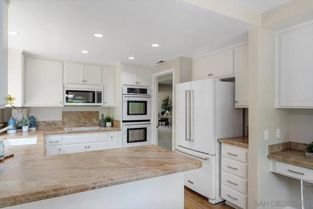 3355 Lower Ridge Road San Diego, CA 92130 - Photo 8 of 31 a kitchen with stainless steel appliances a refrigerator and a stove top oven