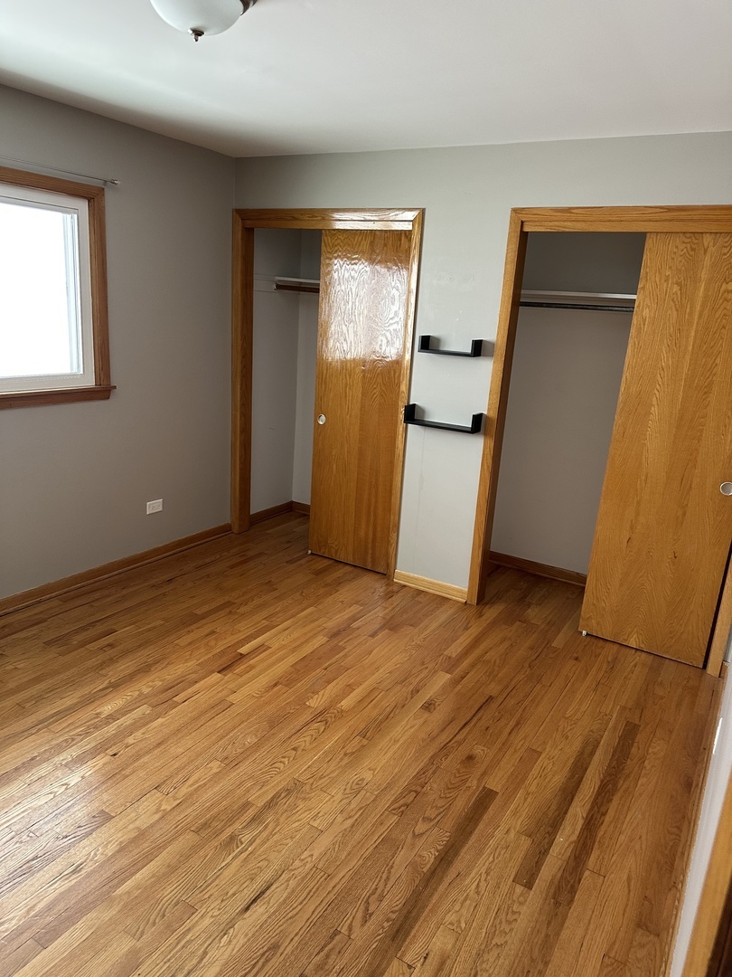1342 Clinton Avenue Berwyn, IL 60402 - Photo 7 of 16 a view of an empty room with wooden floor and a window