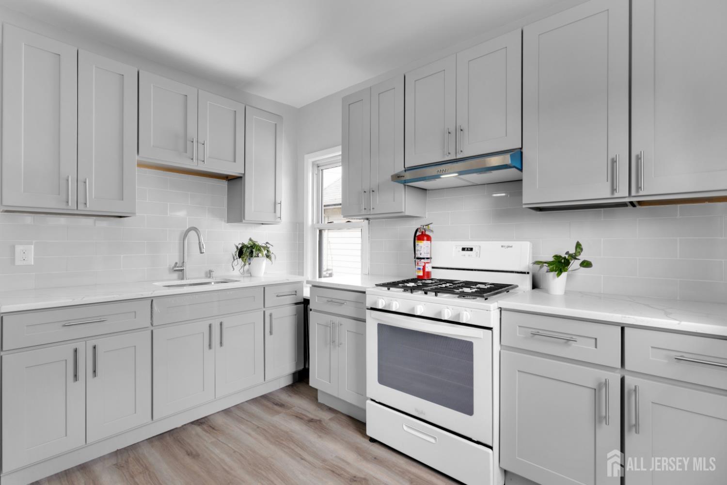 a kitchen with white cabinets and white appliances