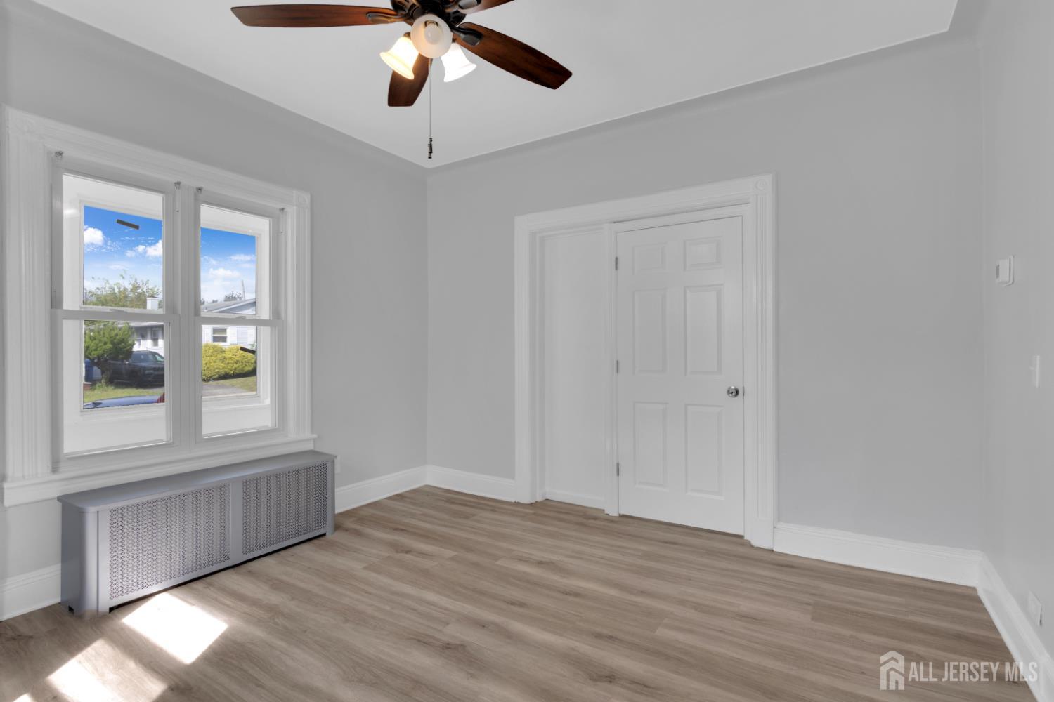 36 3rd Avenue, Unit B Port Reading, NJ 07064 - Photo 11 of 21 a view of an empty room with wooden floor and a window