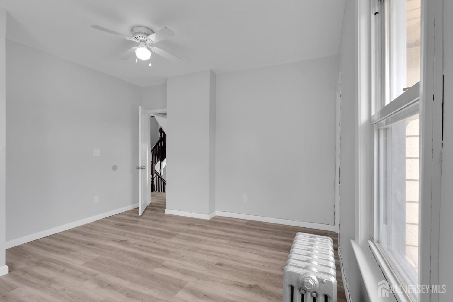 36 3rd Avenue, Unit B Port Reading, NJ 07064 - Photo 10 of 21 a view of empty room with wooden floor and fan