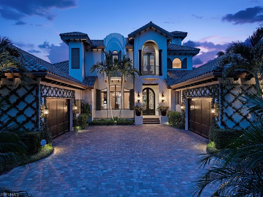a view of a brick house with many windows and a yard