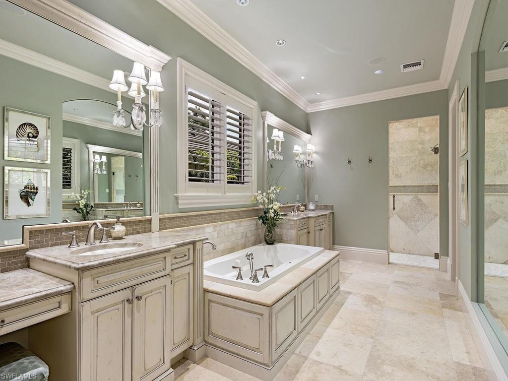 515 Riviera Drive Naples, FL 34103 - Photo 20 of 35 a bathroom with a sink double vanity mirror and a bathtub