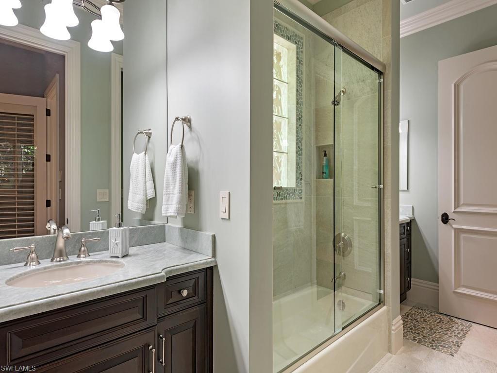 515 Riviera Drive Naples, FL 34103 - Photo 28 of 35 a bathroom with a granite countertop sink shower and a mirror
