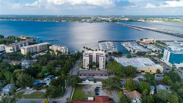 an aerial view of a city with lots of residential buildings ocean and mountain view in back