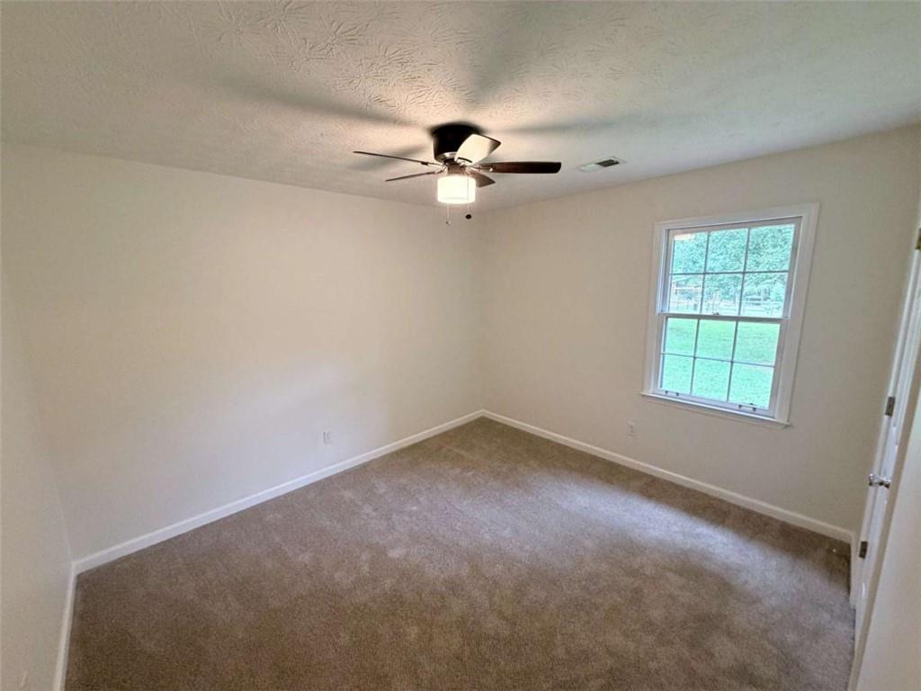 185 Roberts Road Covington, GA 30016 - Photo 16 of 25 an empty room with a window and a ceiling fan