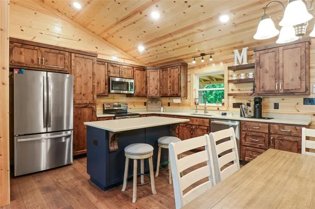 a kitchen with stainless steel appliances granite countertop a refrigerator a stove a sink dishwasher a microwave oven with cabinets and wooden floor