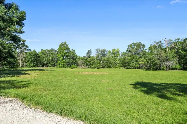 a view of a green field with wooden fence