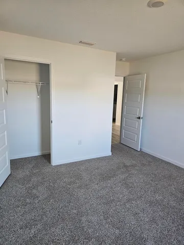 an empty room with closet and mirror
