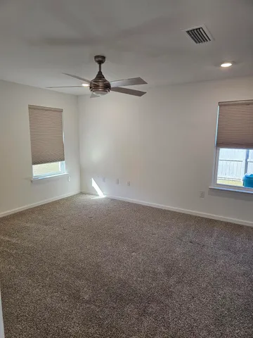 an empty room with a window and a fan
