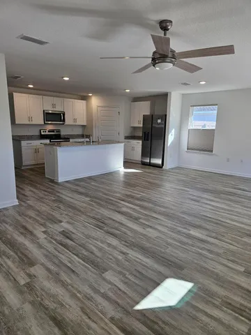 a view of kitchen with cabinets appliances and wooden floor