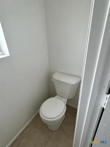 a white toilet sitting next to a white cabinet