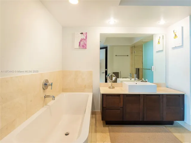 a bathroom with a sink mirror and a bathtub