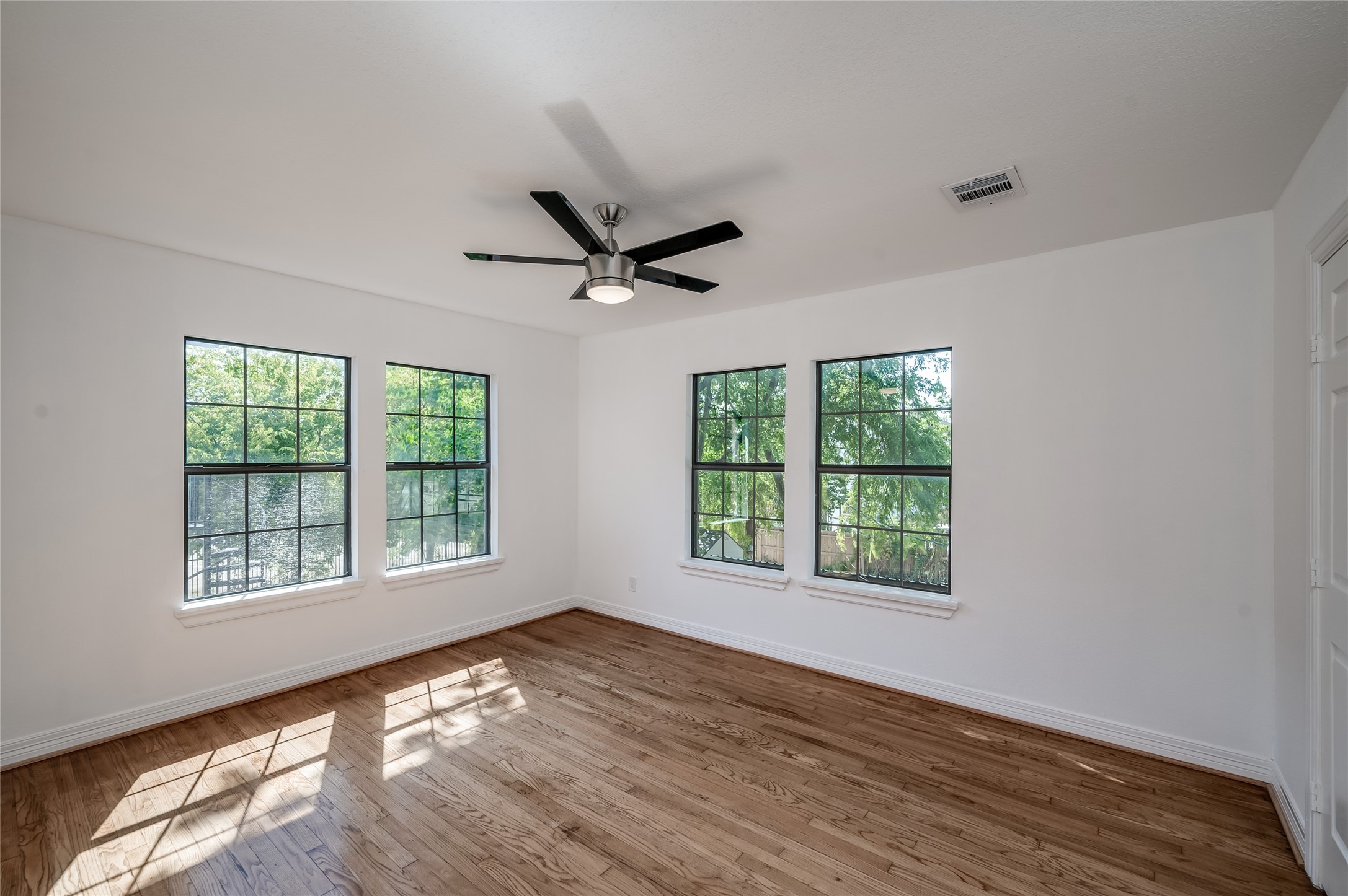 2308 Blodgett Street Houston, TX 77004 - Photo 13 of 23 a view of an empty room with wooden floor and a window
