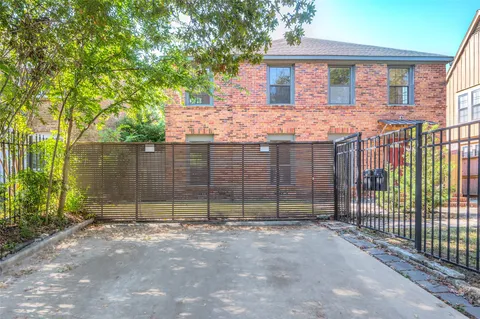 a view of a house with a fence and a tree
