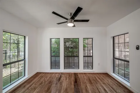 a view of a livingroom with wooden floor and a ceiling fan