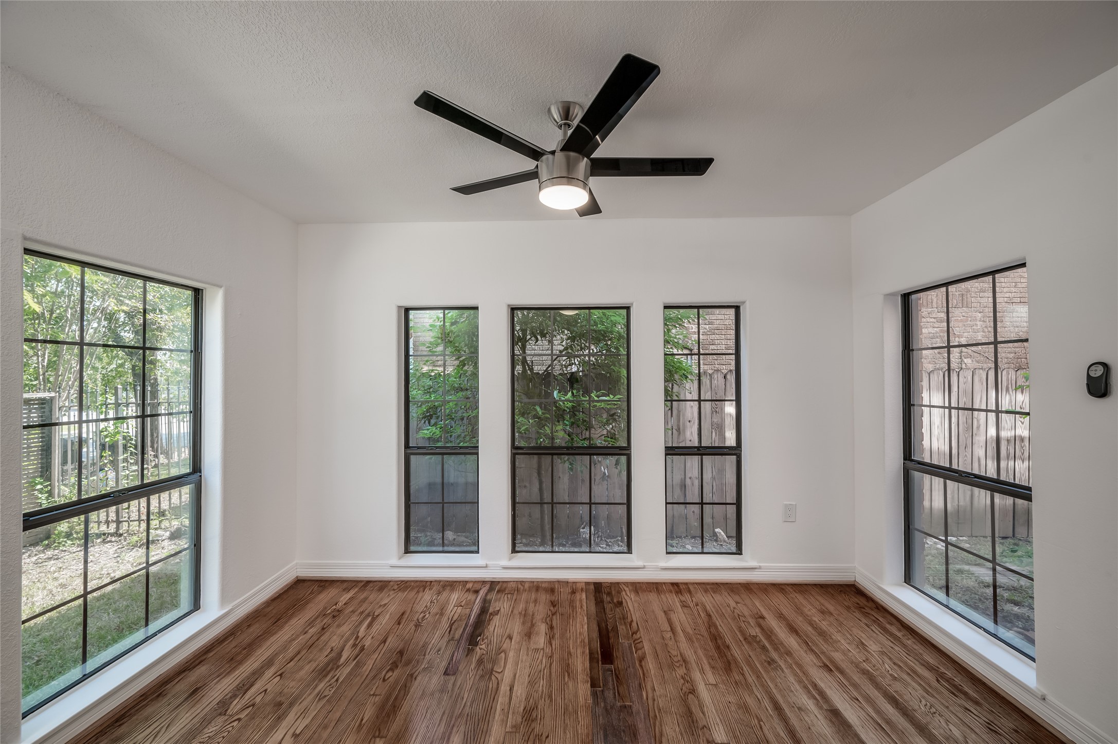 2308 Blodgett Street Houston, TX 77004 - Photo 8 of 23 a view of a livingroom with wooden floor and a ceiling fan