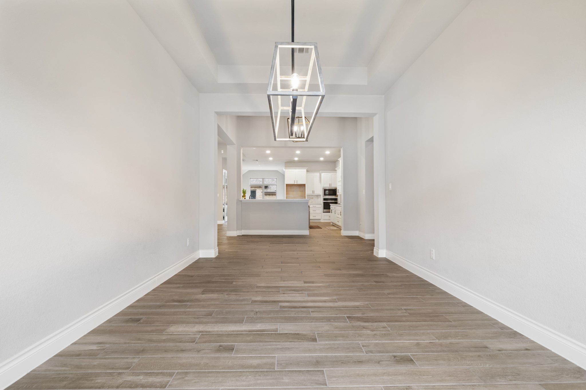 104 Catani Loop Georgetown, TX 78628 - Photo 23 of 34 This interior space features wood-look tile flooring, white walls, and a contemporary ceiling light fixture